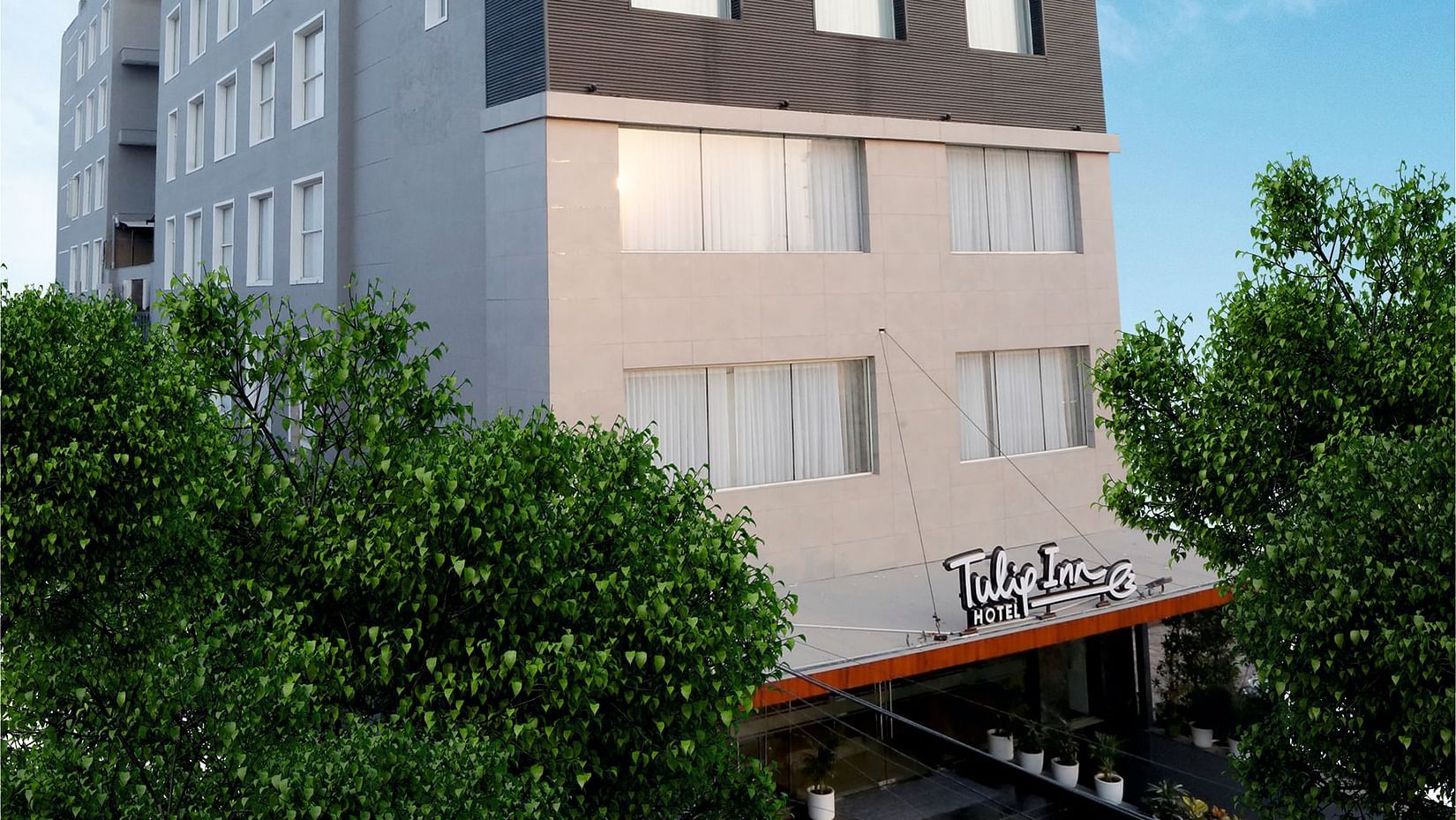 A facade image of TulipInn Zirakpur surrounded by trees in Rishikesh
